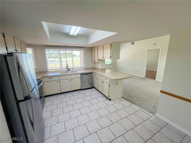 1706 Forest Lakes Blvd, Naples, FL 34105 - kitchen with stainless steel appliances, a sink, a raised ceiling, light countertops, and a peninsula