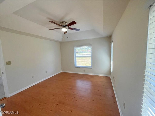 1706 Forest Lakes Blvd, Naples, FL 34105 - empty room featuring a tray ceiling, ceiling fan, wood finished floors, and baseboards