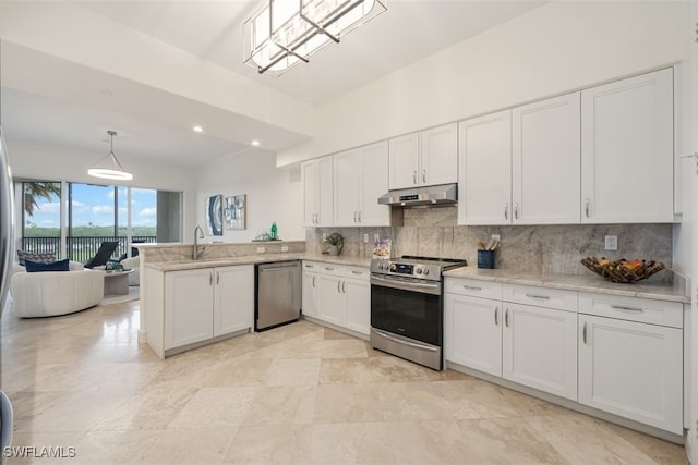 560 El Camino Real Unit 1304, Naples, FL 34119 - kitchen with appliances with stainless steel finishes, under cabinet range hood, a peninsula, white cabinetry, and backsplash