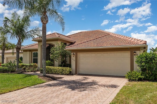 16121 Sand Ridge Ct, Fort Myers, FL 33908 - mediterranean / spanish-style home featuring stucco siding, decorative driveway, a front lawn, a tile roof, and a garage
