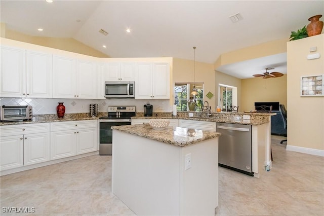 16121 Sand Ridge Ct, Fort Myers, FL 33908 - kitchen featuring appliances with stainless steel finishes, a peninsula, ceiling fan, lofted ceiling, and light tile patterned flooring