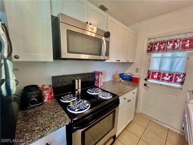 118 Alcala Ave, Lehigh Acres, FL 33936 - kitchen featuring stainless steel appliances, white cabinets, light tile patterned floors, and dark stone counters
