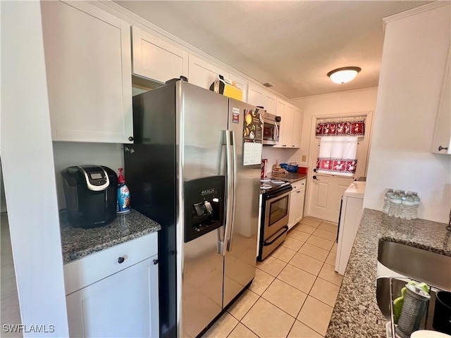 118 Alcala Ave, Lehigh Acres, FL 33936 - kitchen with appliances with stainless steel finishes, white cabinets, light tile patterned flooring, a sink, and washer / dryer