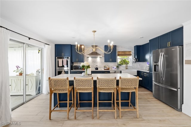 1549 Sandpiper St Unit 39, Naples, FL 34102 - kitchen featuring appliances with stainless steel finishes, blue cabinetry, a chandelier, and light countertops