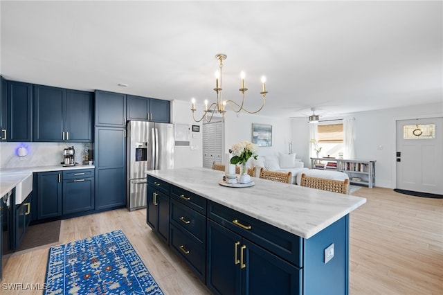 1549 Sandpiper St Unit 39, Naples, FL 34102 - kitchen featuring stainless steel fridge with ice dispenser, a center island, a ceiling fan, a chandelier, and light wood-type flooring