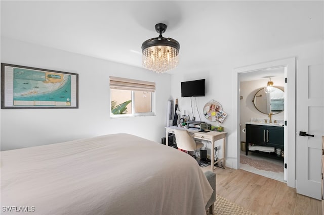 1549 Sandpiper St Unit 39, Naples, FL 34102 - bedroom featuring a chandelier, light wood-type flooring, and ensuite bathroom