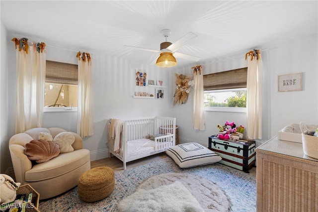 1549 Sandpiper St Unit 39, Naples, FL 34102 - bedroom with wood finished floors, baseboards, a crib, and a ceiling fan