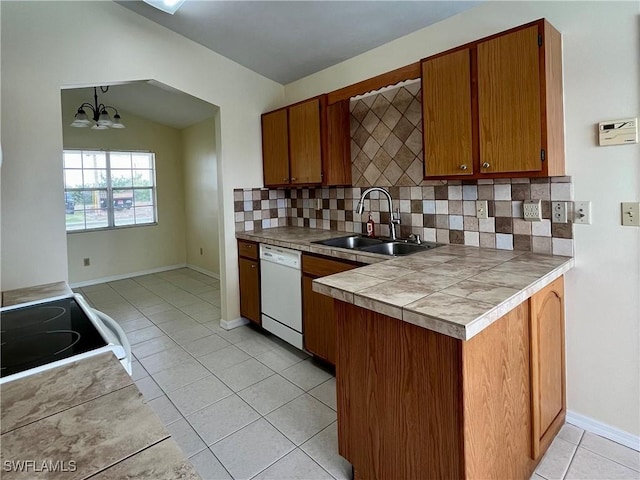 kitchen with white dishwasher, a sink, light tile patterned floors, a chandelier, and decorative backsplash