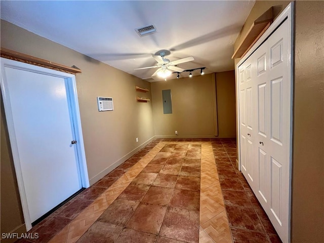hallway featuring electric panel, track lighting, and baseboards