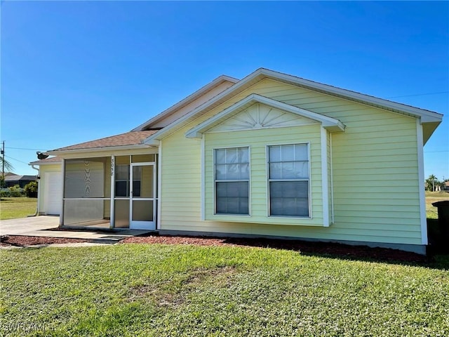back of property featuring a lawn and a shingled roof
