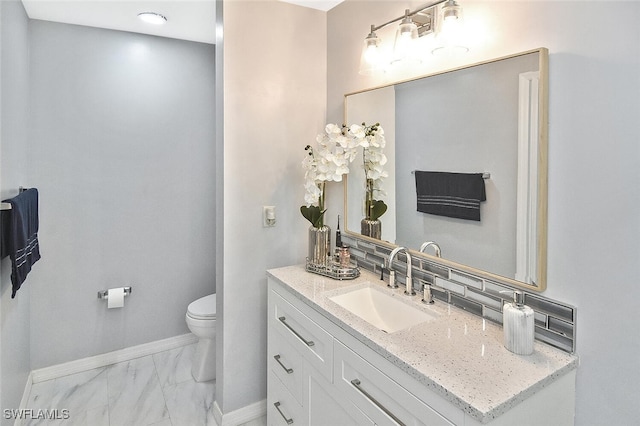 3408 26th St SW, Lehigh Acres, FL 33976 - bathroom with vanity, marble finish floors, baseboards, toilet, and backsplash