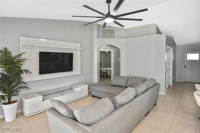 3408 26th St SW, Lehigh Acres, FL 33976 - living room featuring arched walkways, light tile patterned floors, a ceiling fan, and baseboards
