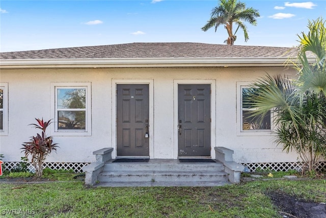 25/27 Cypress St, North Fort Myers, FL 33903 - doorway to property with roof with shingles and stucco siding
