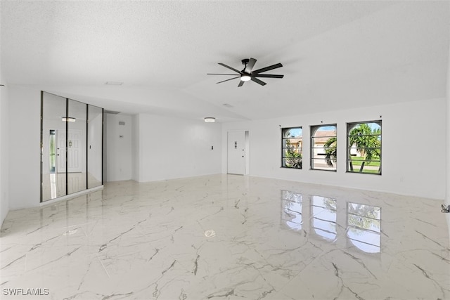 1306 SW 10th Pl, Cape Coral, FL 33991 - spare room featuring marble tiled flooring, ceiling fan, vaulted ceiling, and a textured ceiling