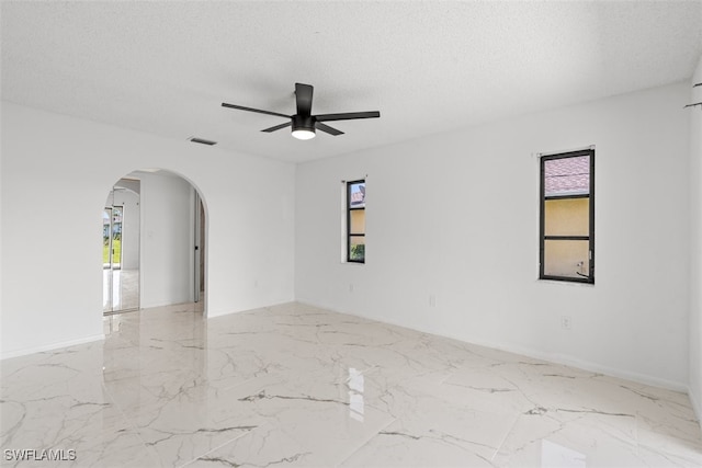 1306 SW 10th Pl, Cape Coral, FL 33991 - spare room with arched walkways, healthy amount of natural light, ceiling fan, marble tiled floors, and a textured ceiling