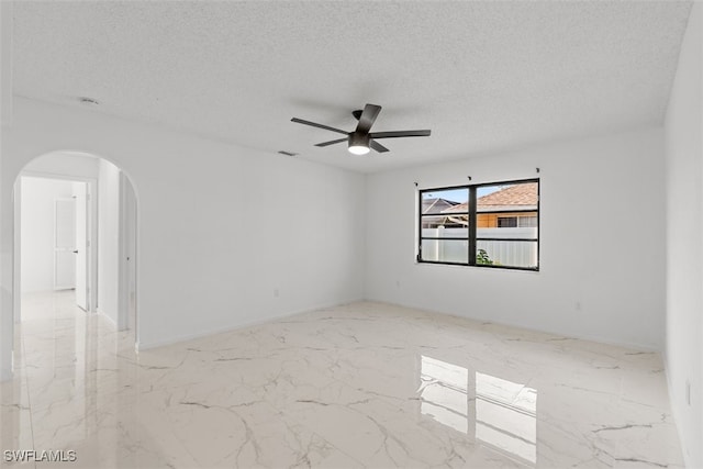 1306 SW 10th Pl, Cape Coral, FL 33991 - unfurnished room with arched walkways, ceiling fan, marble tiled flooring, and a textured ceiling