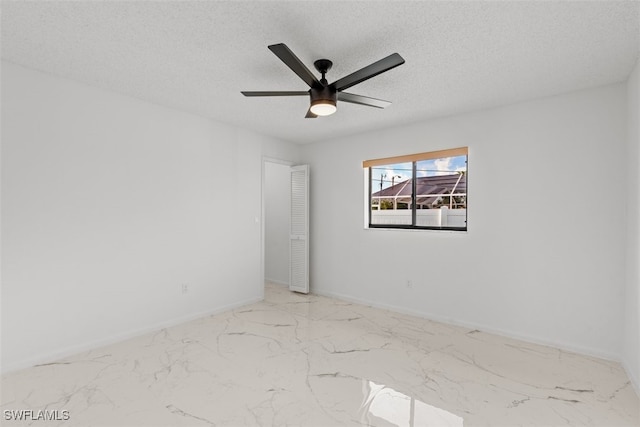 1306 SW 10th Pl, Cape Coral, FL 33991 - spare room with marble finish floors, a textured ceiling, a ceiling fan, and baseboards