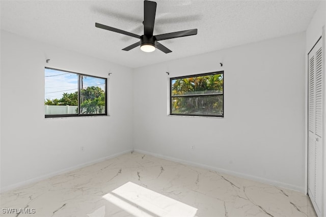 1306 SW 10th Pl, Cape Coral, FL 33991 - unfurnished bedroom featuring multiple windows, a textured ceiling, marble finish flooring, baseboards, and a closet