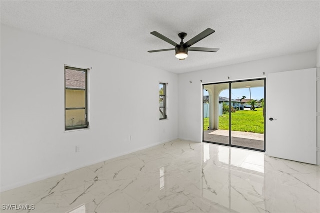 1306 SW 10th Pl, Cape Coral, FL 33991 - unfurnished room with marble tiled floors, ceiling fan, a textured ceiling, and baseboards