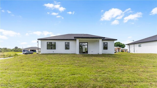 3315 Sunshine Blvd N, Lehigh Acres, FL 33971 - back of property with a yard and stucco siding