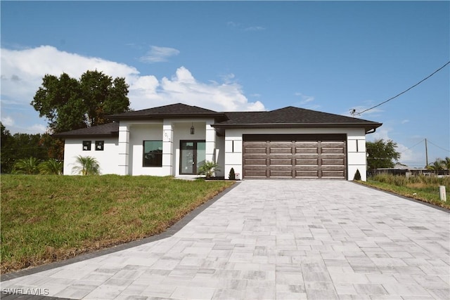 1013 Agnes Ave, Lehigh Acres, FL 33971 - prairie-style house with stucco siding, decorative driveway, a front yard, and an attached garage