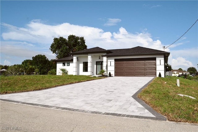 1013 Agnes Ave, Lehigh Acres, FL 33971 - prairie-style home with a garage, stucco siding, decorative driveway, and a front lawn