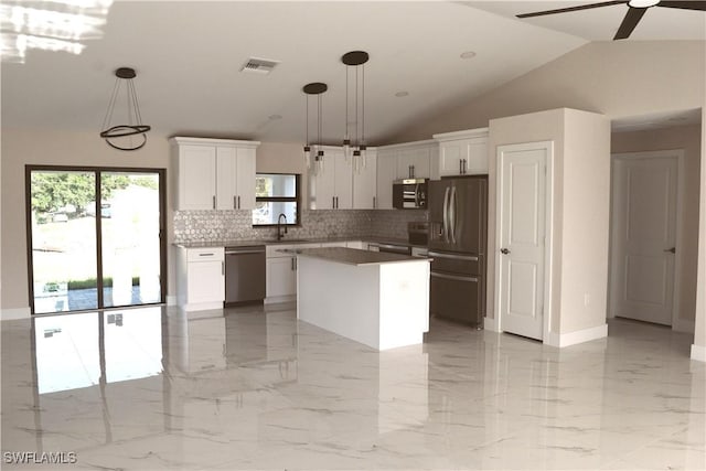 1013 Agnes Ave, Lehigh Acres, FL 33971 - kitchen with appliances with stainless steel finishes, a sink, tasteful backsplash, white cabinets, and a kitchen island