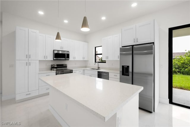 2811 27th St SW, Lehigh Acres, FL 33976 - kitchen featuring stainless steel appliances, a kitchen island, white cabinets, a sink, and pendant lighting