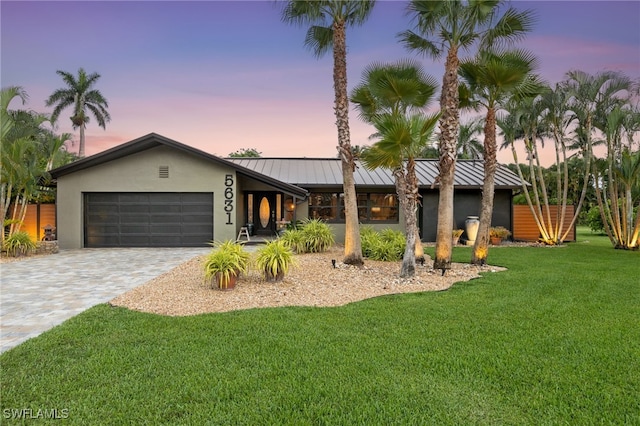 5631 Shaddelee Ln W, Fort Myers, FL 33919 - mid-century home featuring a standing seam roof, a garage, a front lawn, and stucco siding