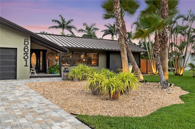 5631 Shaddelee Ln W, Fort Myers, FL 33919 - view of front facade with a standing seam roof, stucco siding, a metal roof, and a front yard