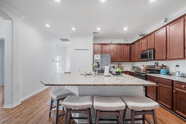 9052 Glenforest Dr, Naples, FL 34120 - kitchen featuring stainless steel appliances, a breakfast bar area, light wood-type flooring, an island with sink, and crown molding