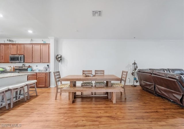 9052 Glenforest Dr, Naples, FL 34120 - dining room featuring ornamental molding, light wood-type flooring, and recessed lighting