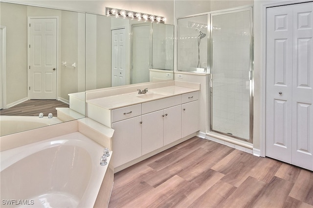 19741 Vintage Trace Cir, Estero, FL 33967 - full bathroom featuring a garden tub, vanity, a stall shower, and wood finished floors