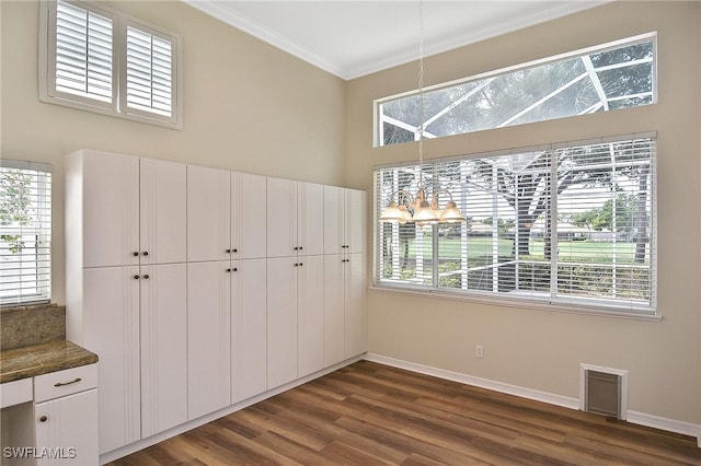 19741 Vintage Trace Cir, Estero, FL 33967 - unfurnished dining area featuring dark wood-style flooring, crown molding, baseboards, and healthy amount of natural light