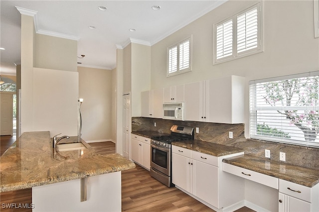 19741 Vintage Trace Cir, Estero, FL 33967 - kitchen with stainless steel gas range, white microwave, a sink, a towering ceiling, and light wood finished floors