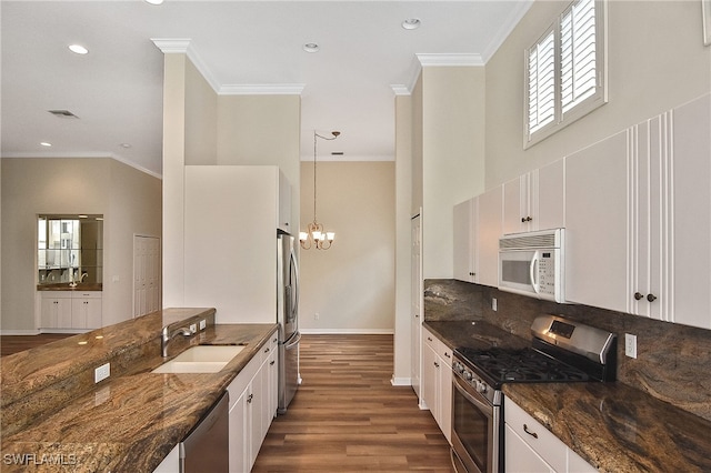 19741 Vintage Trace Cir, Estero, FL 33967 - kitchen featuring appliances with stainless steel finishes, a sink, dark stone counters, white cabinets, and crown molding