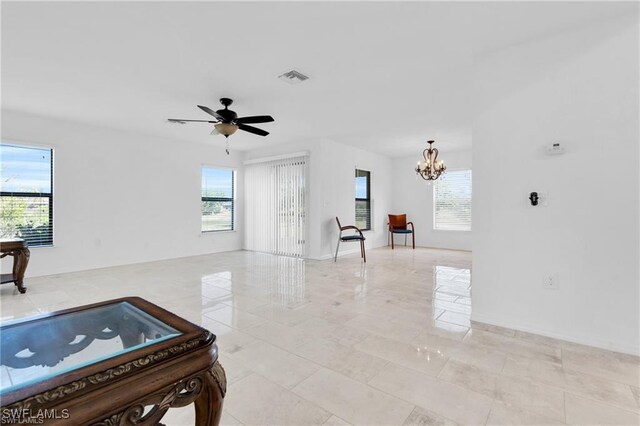 154 Shadowview Ct, Lehigh Acres, FL 33974 - unfurnished living room with healthy amount of natural light, a chandelier, and ceiling fan
