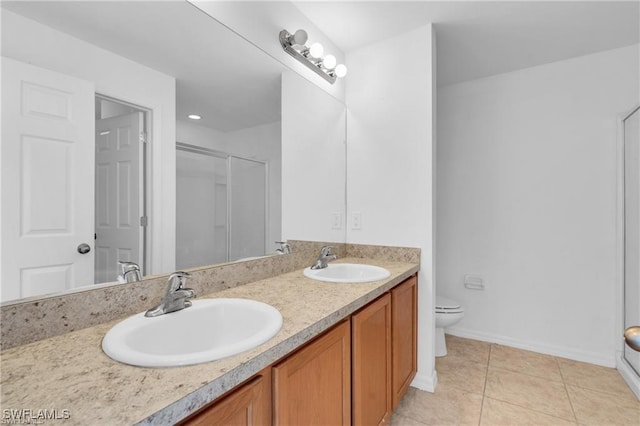 154 Shadowview Ct, Lehigh Acres, FL 33974 - bathroom featuring double vanity, a stall shower, toilet, tile patterned floors, and baseboards