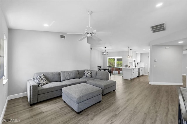 10268 Boca Cir, Naples, FL 34109 - living room with ceiling fan, baseboards, wood finished floors, recessed lighting, and a chandelier
