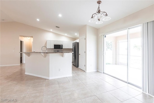 2121 NW 18th Pl, Cape Coral, FL 33993 - kitchen featuring stainless steel appliances, lofted ceiling, a breakfast bar, white cabinetry, and decorative light fixtures