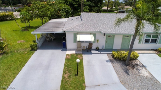 4 Desert Candle Cir, Lehigh Acres, FL 33936 - view of front of house featuring concrete driveway, roof with shingles, a front yard, a carport, and a porch