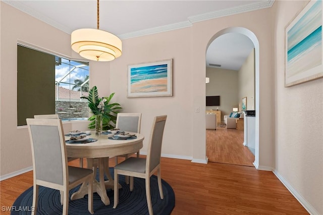 1435 Vintage Ln, Naples, FL 34104 - dining room featuring wood finished floors, ornamental molding, and arched walkways