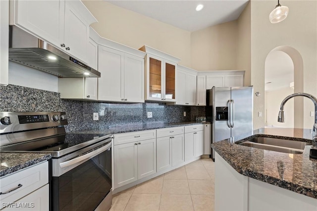 1435 Vintage Ln, Naples, FL 34104 - kitchen with appliances with stainless steel finishes, under cabinet range hood, white cabinets, decorative backsplash, and dark stone countertops