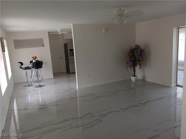 2244 Parkview Dr, Fort Myers, FL 33905 - spare room featuring a ceiling fan, light marble finish floors, baseboards, and plenty of natural light