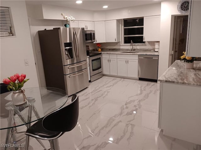 2244 Parkview Dr, Fort Myers, FL 33905 - kitchen featuring stainless steel appliances, a sink, light marble finish floors, white cabinetry, and recessed lighting