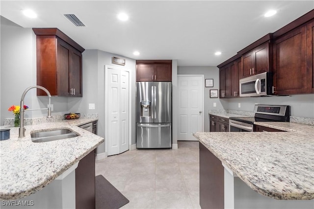 14121 Roof St, Fort Myers, FL 33905 - kitchen with stainless steel appliances, a sink, light stone countertops, recessed lighting, and a peninsula