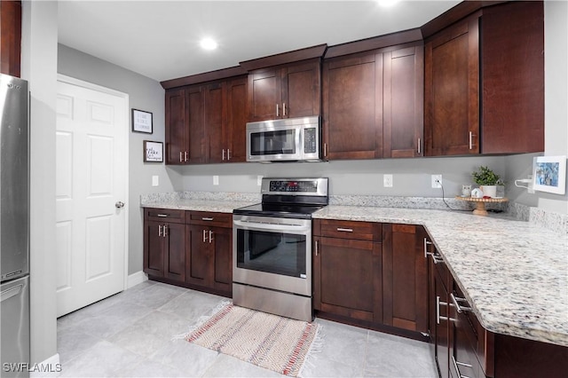 14121 Roof St, Fort Myers, FL 33905 - kitchen featuring appliances with stainless steel finishes, light stone countertops, dark brown cabinetry, and recessed lighting