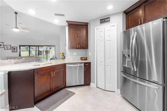14121 Roof St, Fort Myers, FL 33905 - kitchen with stainless steel appliances, a sink, open floor plan, a peninsula, and light stone countertops