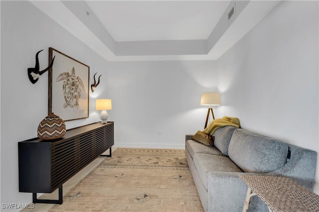 1115 Central Ave Unit 547, Naples, FL 34102 - living room with a tray ceiling, baseboards, and wood finished floors