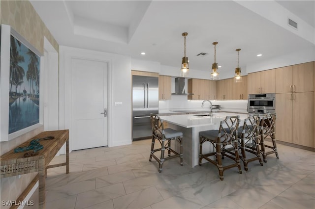 1115 Central Ave Unit 547, Naples, FL 34102 - kitchen with stainless steel appliances, wall chimney exhaust hood, light brown cabinets, a breakfast bar area, and a sink